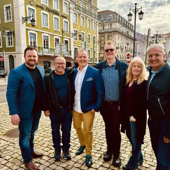 Team members standing together on a cobbled street