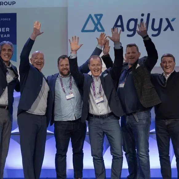 Team celebrating on stage at an Agilyx event
